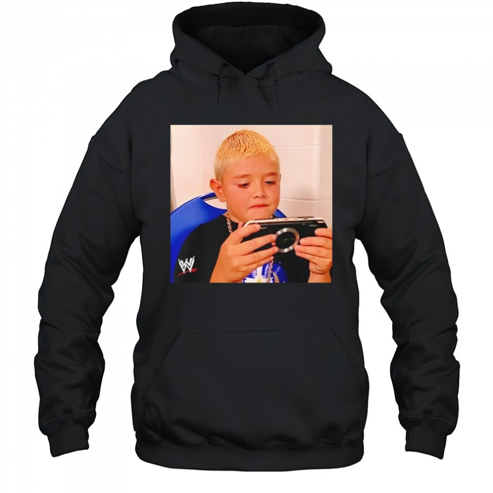 Dominik Mysterio wearing his younger self playing the PSP shirt